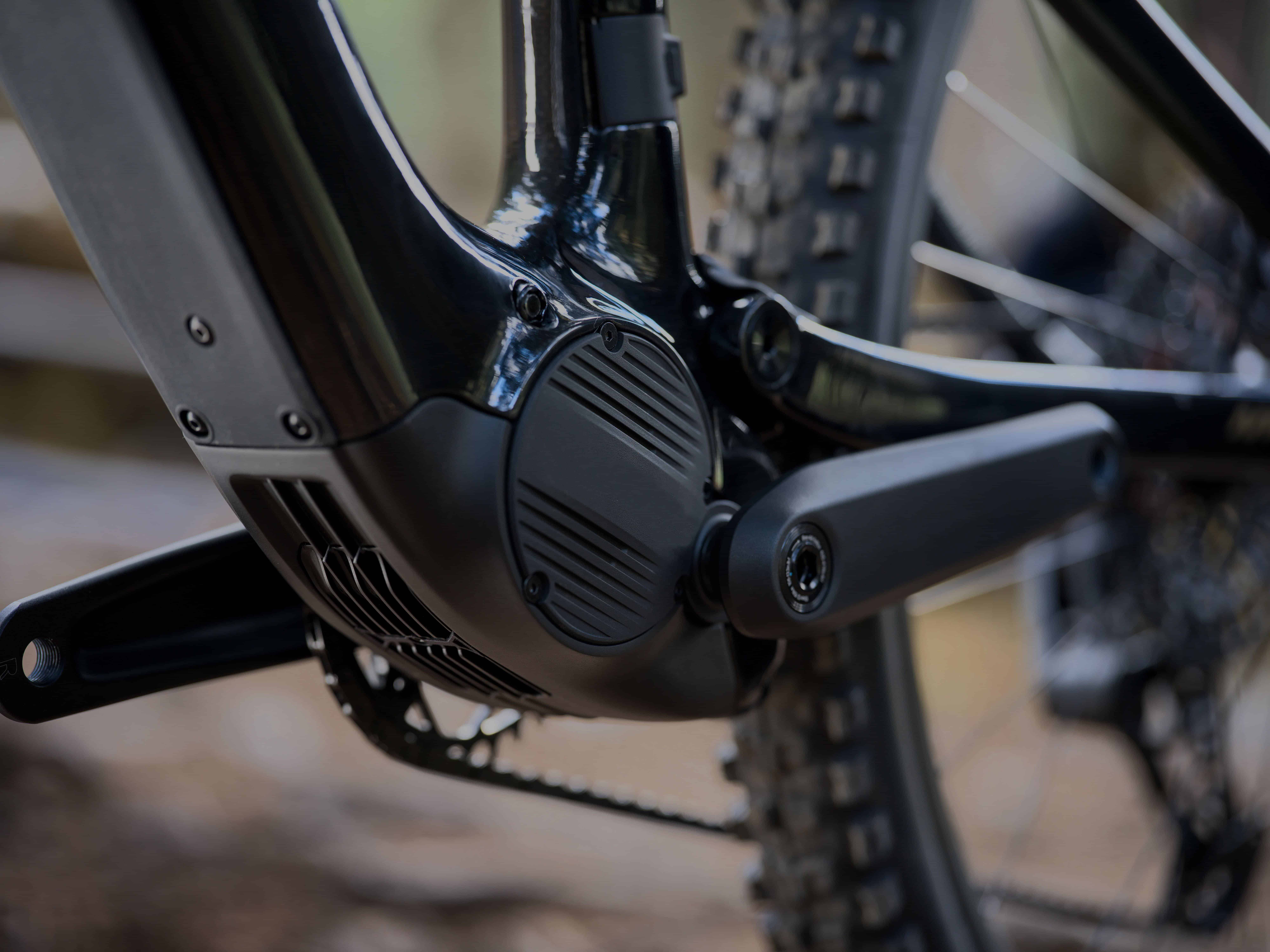 Close-up of a mid-drive e-bike motor, crank arm and chainring