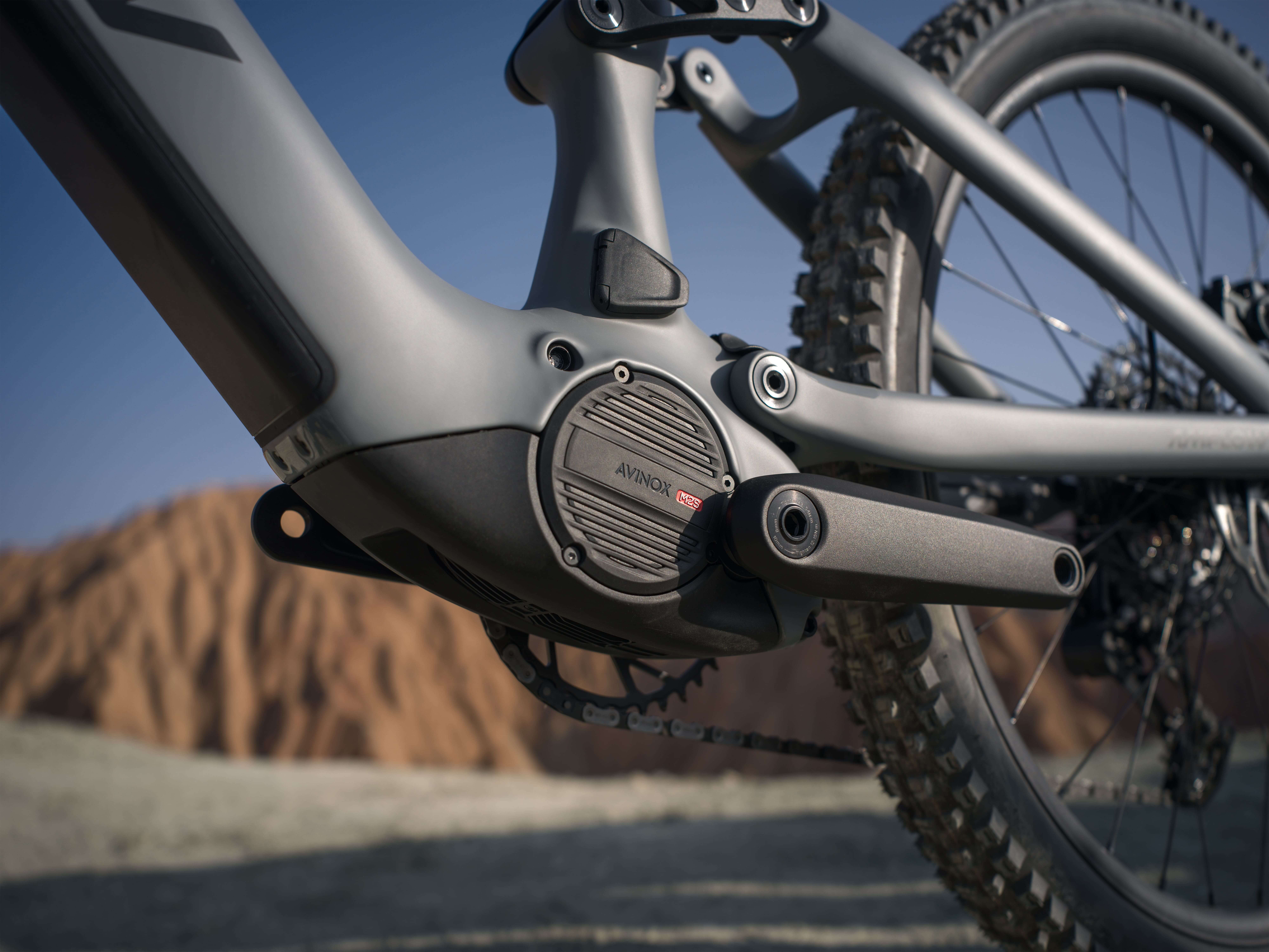 Close-up of an eMTB motor and crankset on a mountain trail
