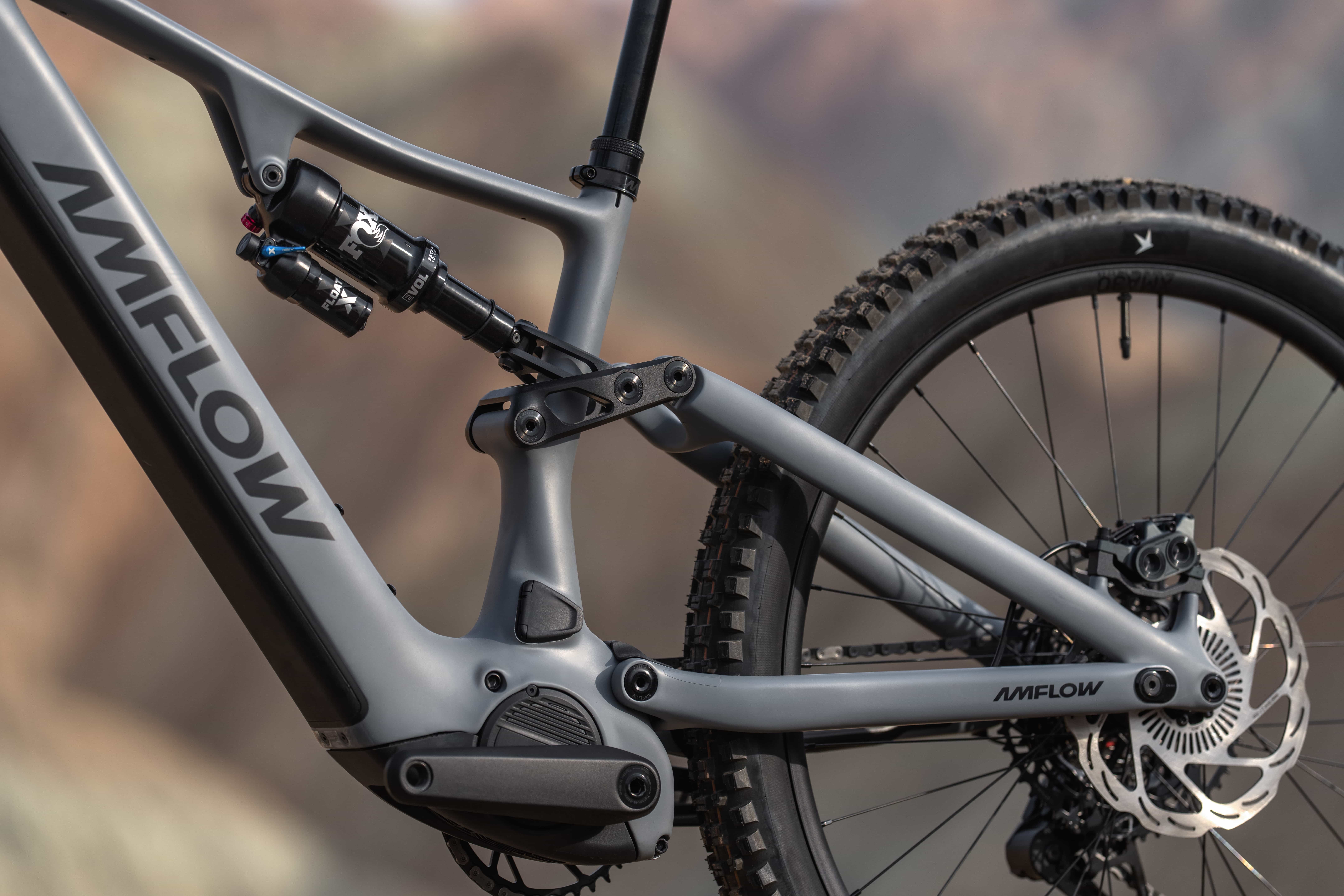 Close-up of AMFLOW e-MTB carbon frame showing the Fox rear shock and four-bar linkage suspension