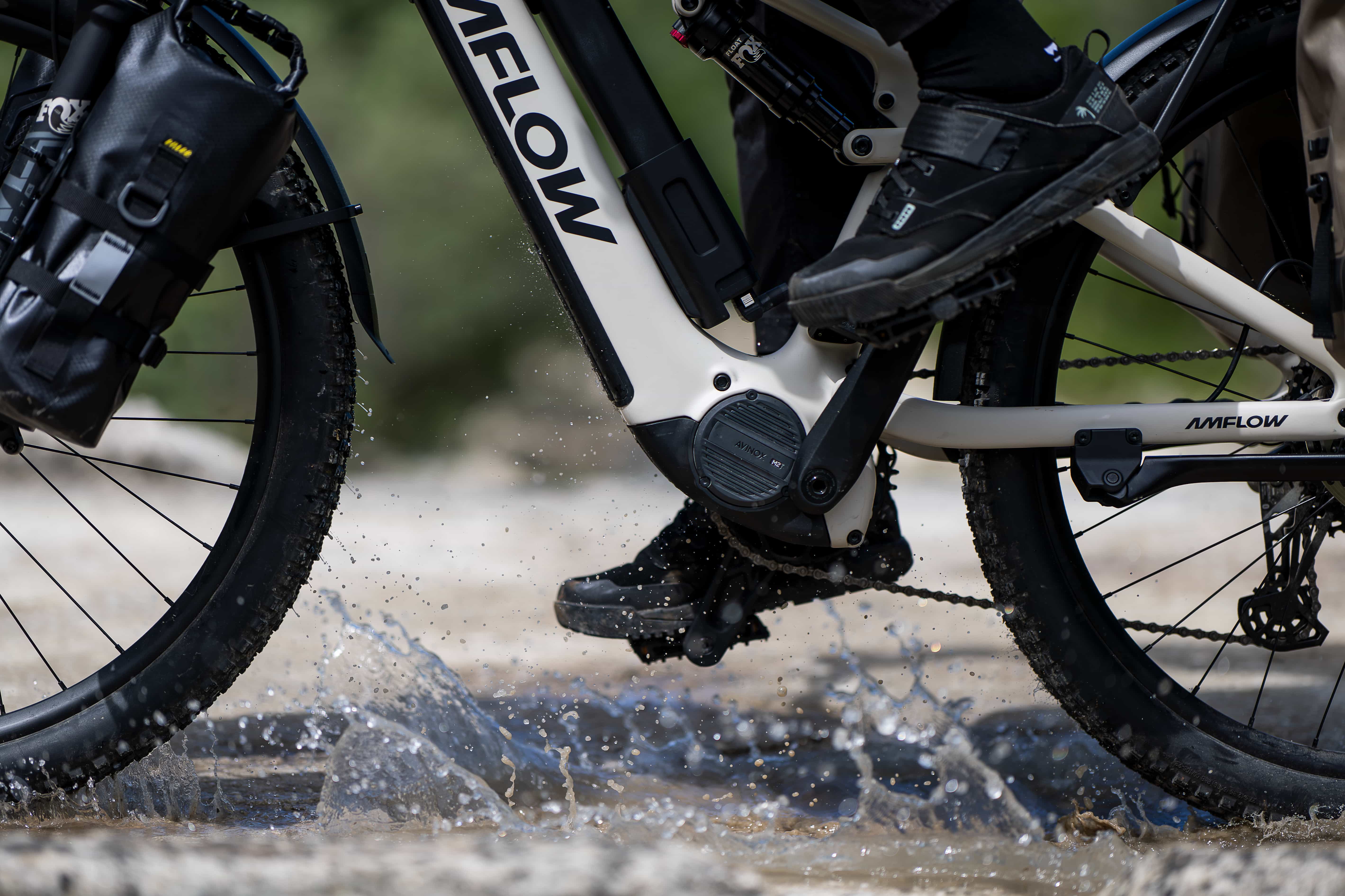 AMFLOW e-bike Avinox M2 mid-drive motor as a rider pedals through a splashing water crossing